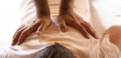 Mains posées à plat sur le dos pendant un shiatsu
